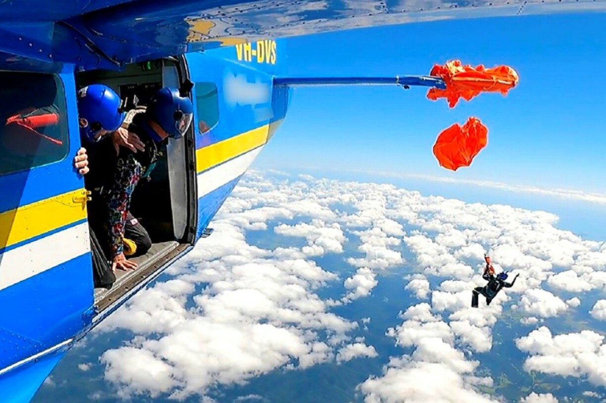 parašutista visící na křídle letadla za padák 