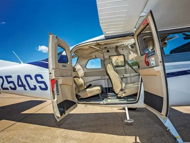 CESSNA pro AEROTAXI na zpevněné ploše s otevřenými dveřmi.