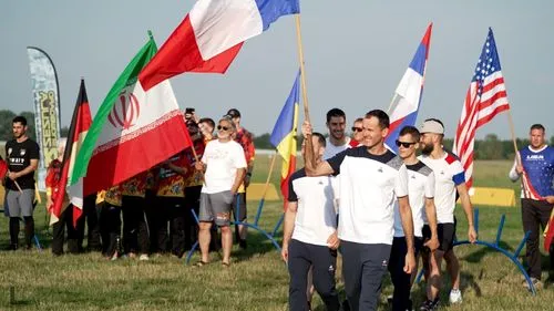 Lidé s vlajkami různých států na louce