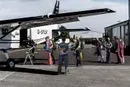 Tandem piloti a pasažéři při nástupu do letadla